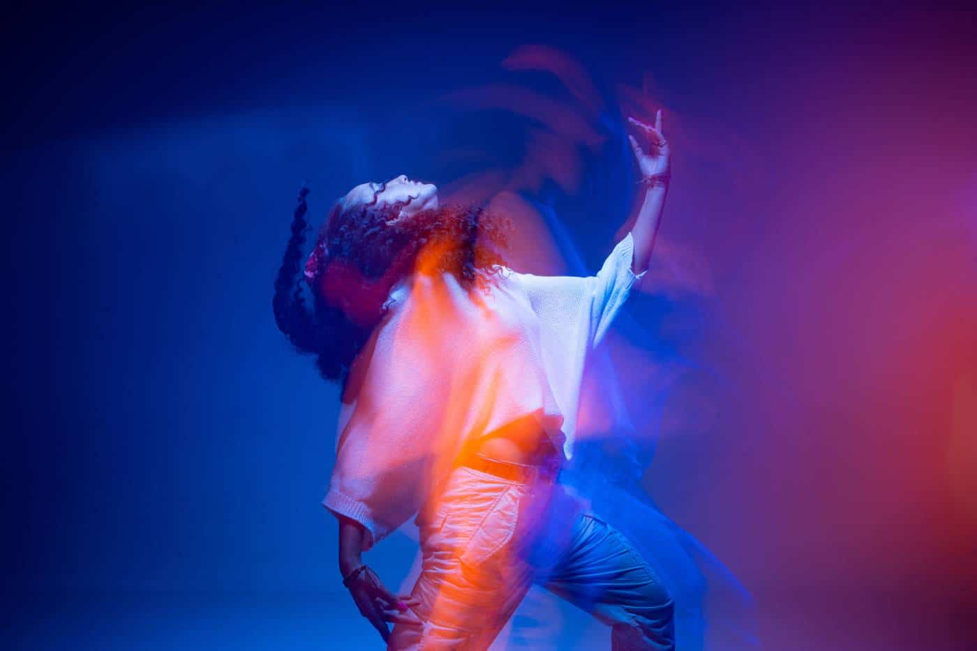 Cool dancing young mixed race girl in colorful neon studio light. Long exposure. Contemporary hip hop dance, rap rhythm AdobeStock 436934772 - Don Du Souffle