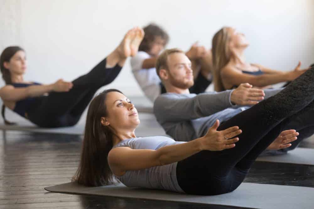 Group of young sporty people in boat pose pilates - Don Du Souffle